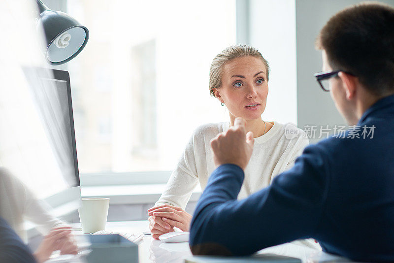 惊讶的女商人在办公室和同事交谈