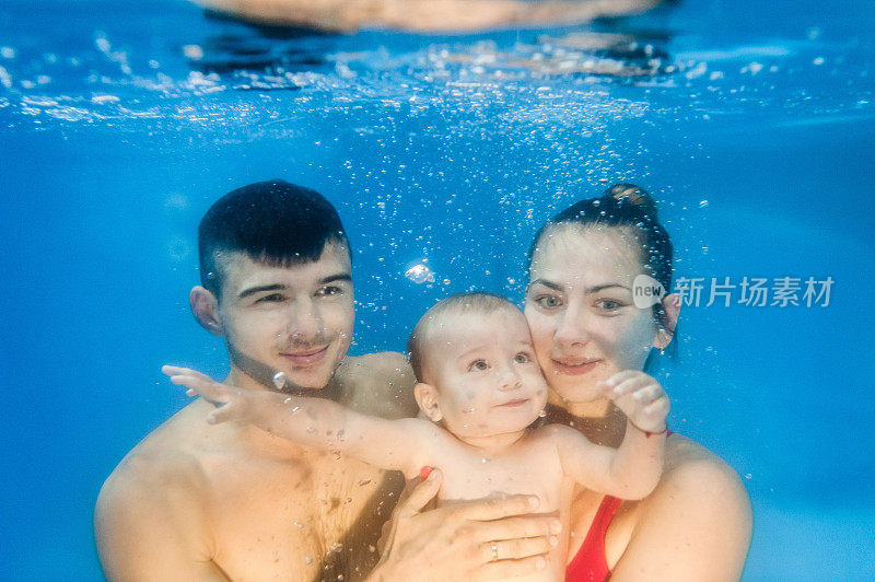 快乐的家庭-母亲，父亲，儿子，潜水与乐趣在海滩游泳池。积极的父母生活方式，人们水上运动活动，周末水上课程和水下儿童游泳课。