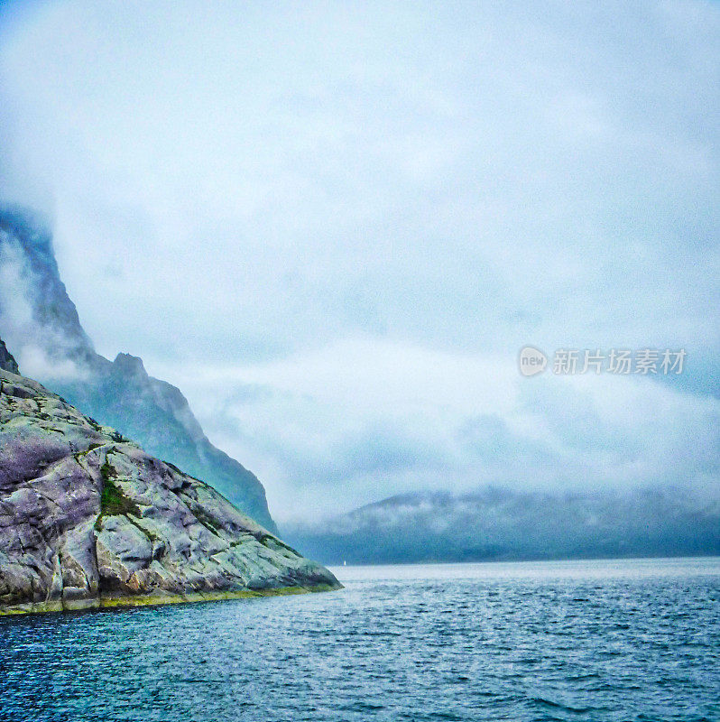 岩石嶙峋的海岸线，薄雾笼罩着峭壁