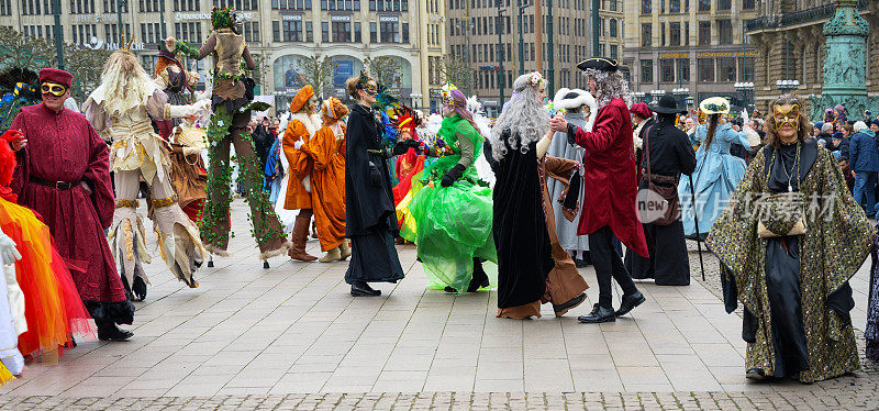 德国汉堡，2020年2月8日:人们穿着五颜六色的服装和面具在汉堡市政厅广场上跳舞，这是一个嘉年华街头节日，作为对威尼斯最初的活动的致敬