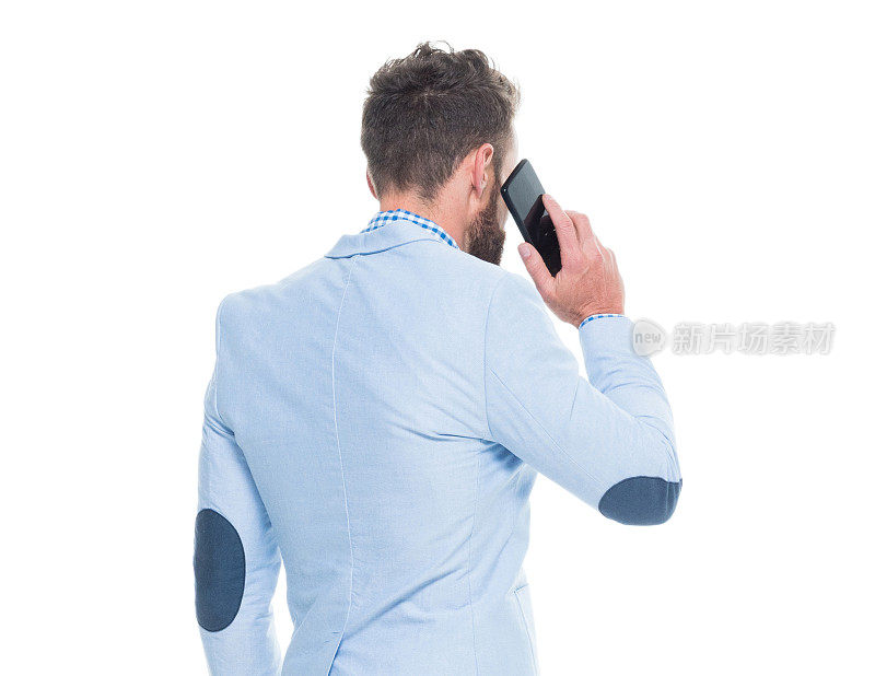 白人年轻男性商人站在白色背景前，系着领带，使用手机