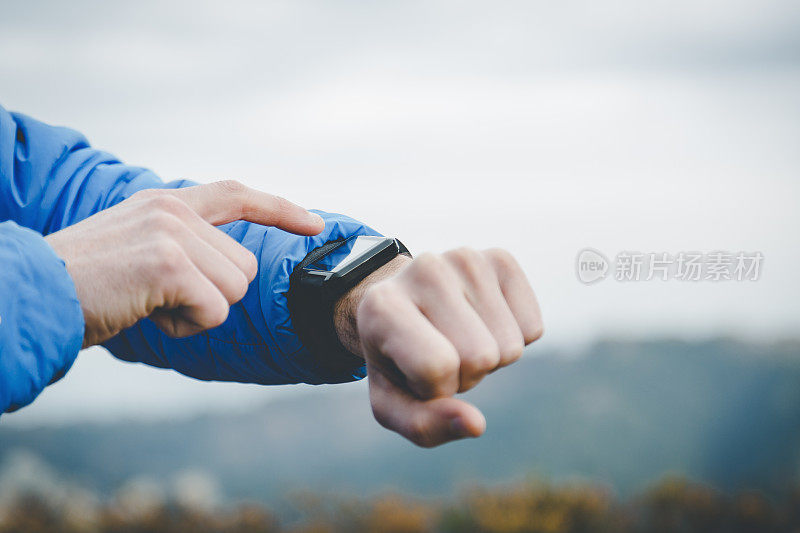 一名男子在登山时使用智能手表