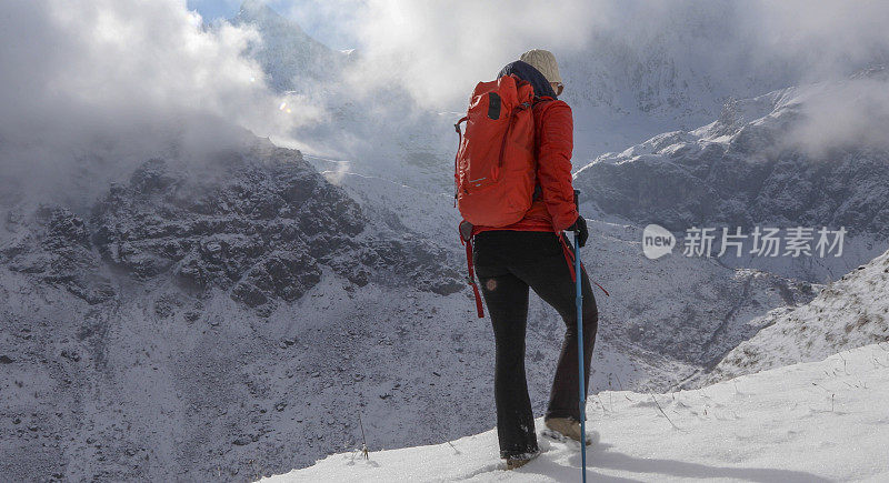 女登山家攀登雪坡，在山上