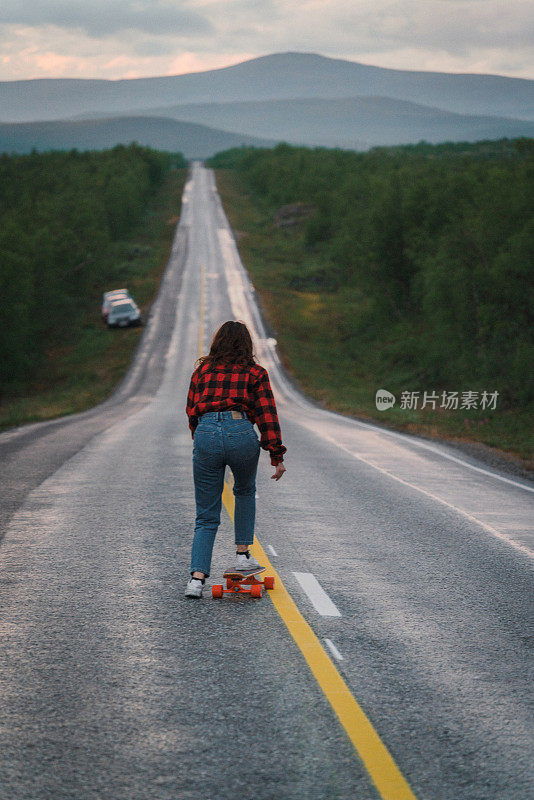 芬兰的一名女子在路上玩长滑板