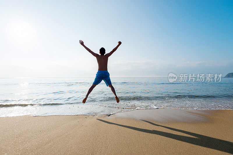 兴奋的男人在海滩上跳