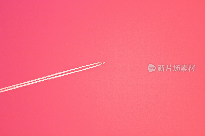 粉红色背景与飞机急流