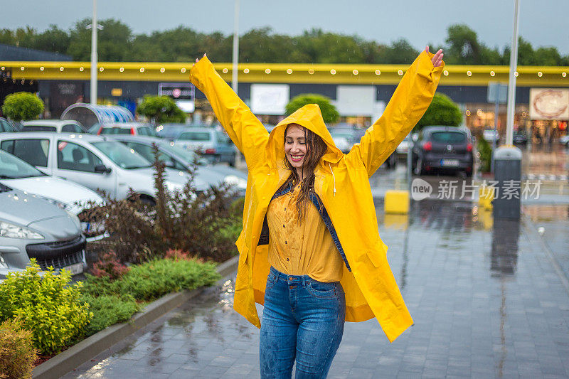 年轻女子快乐地在雨中跳跃