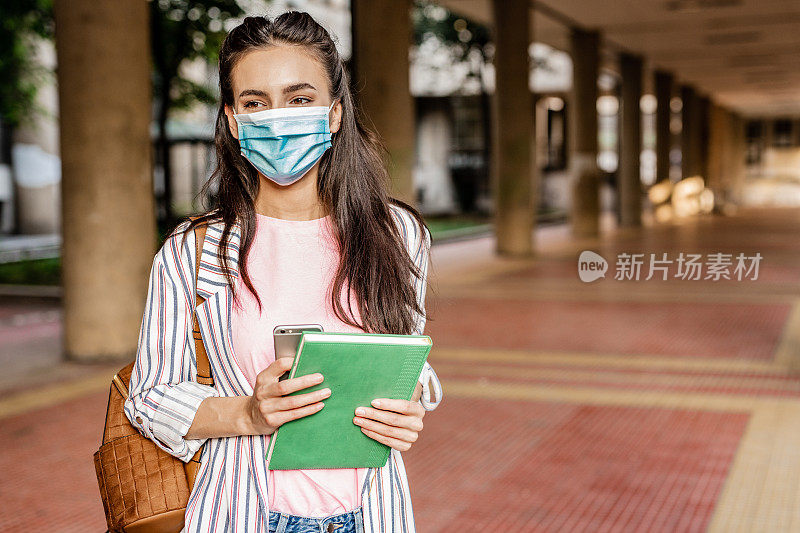 年轻女学生在疫情期间佩戴防护口罩