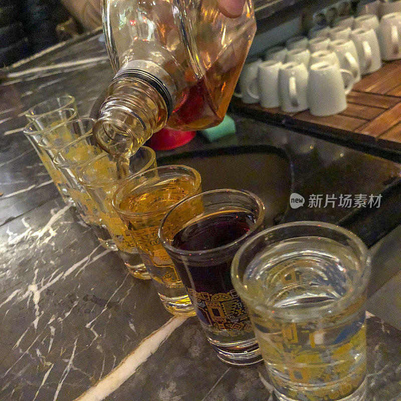 酒保把烈酒倒进玻璃杯里