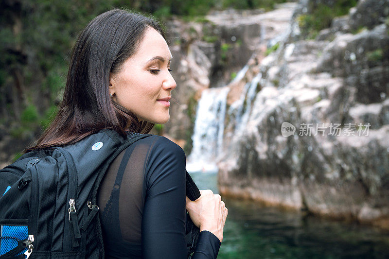 背着背包的年轻女子徒步旅行者在户外的山区旅行