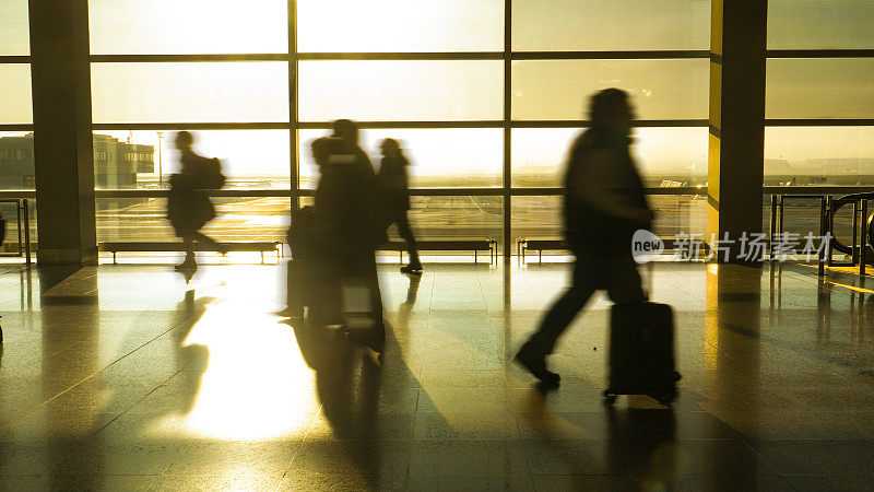 剪影:旅客匆忙穿过机场大厅，试图到达登机口
