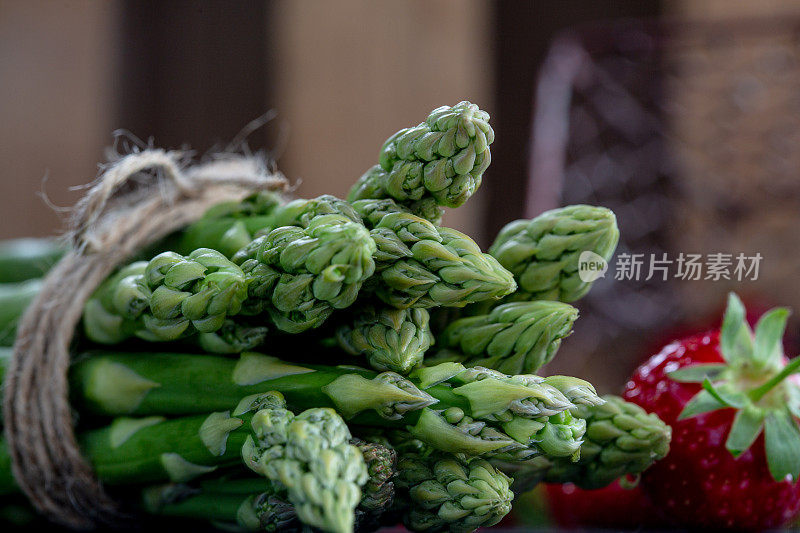 新鲜的绿色芦笋和草莓在深色的背景