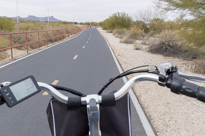 在一个冬季的公共亚利桑那州自行车道上的电动自行车的车把视图