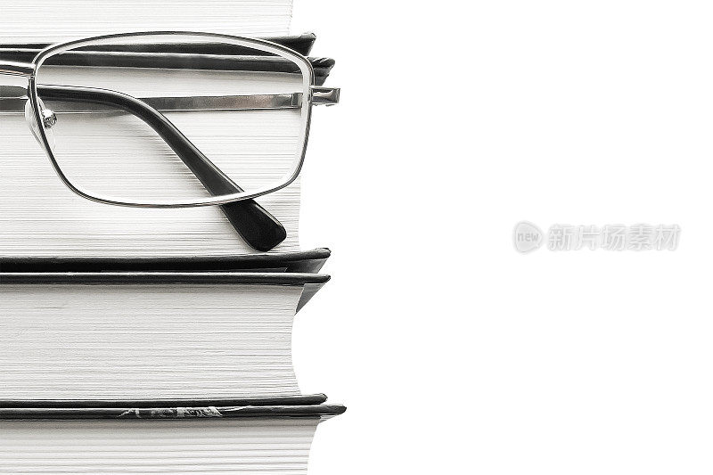 白色背景上的眼镜和厚厚的书。教育理念