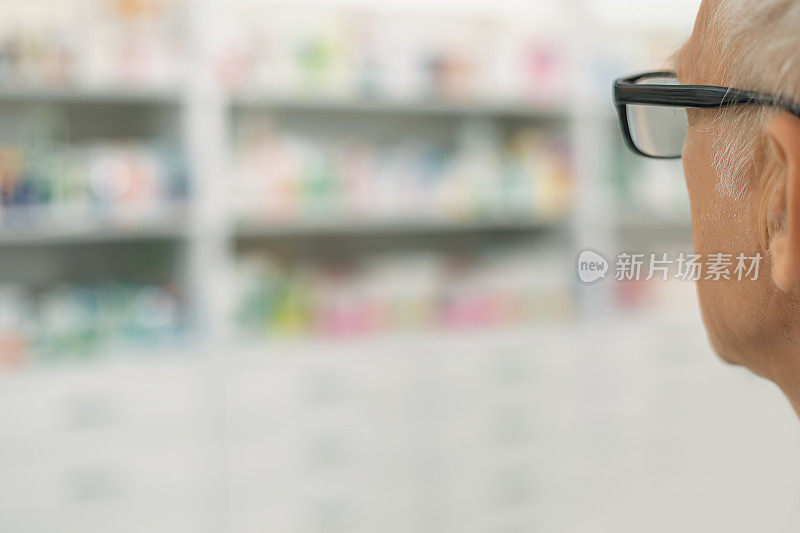 老年购物者戴眼镜在药房近距离从后面与复制空间