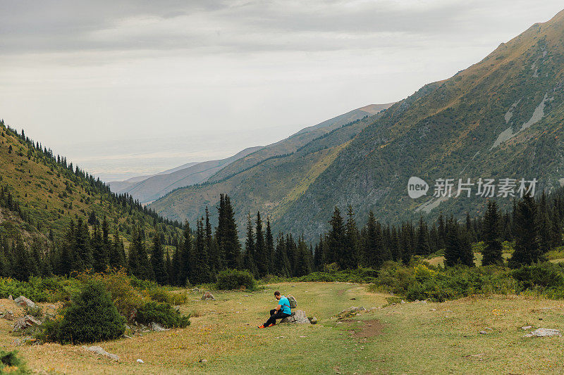 一名背包客在夏天的中亚山区徒步旅行