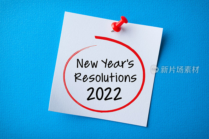 白色便利贴与新年2022决议和红色图钉在蓝色背景