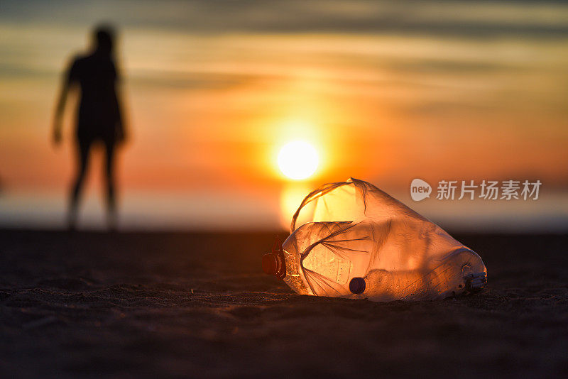 日落时分海滩上的塑料垃圾