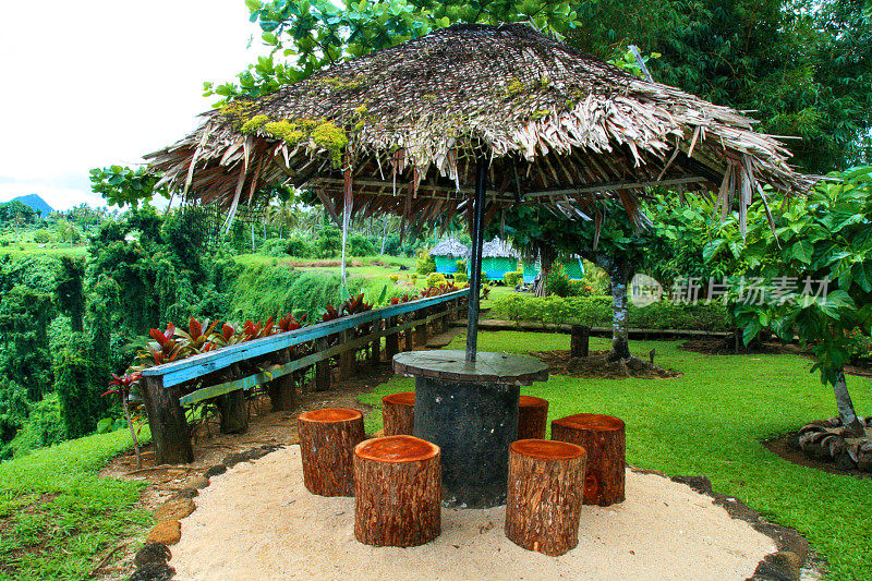 木制传统波利尼西亚庇护与棕榈茅草屋顶在美丽的热带花园与海洋植物和树木，“nSopoaga萨摩亚瀑布度假村，乌波卢岛