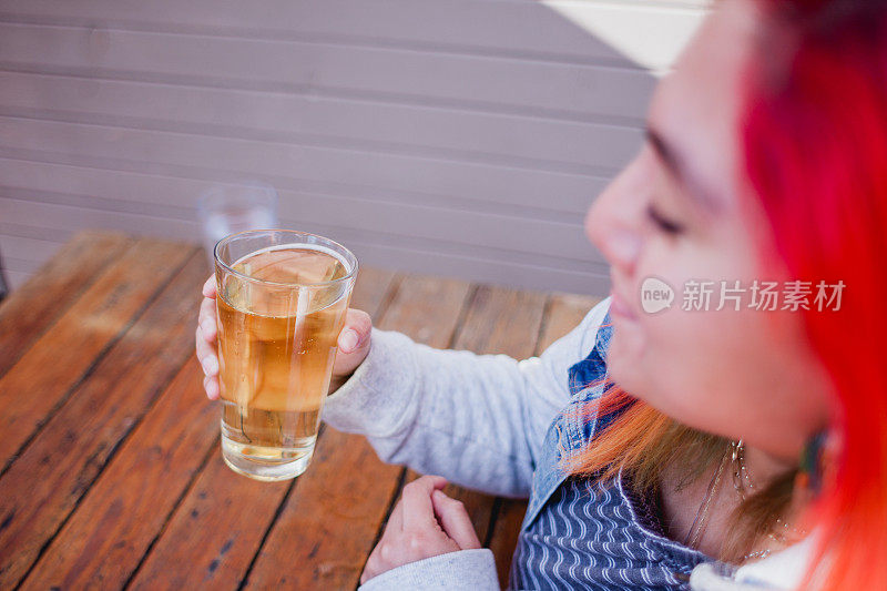 成年女子染头发享受啤酒汉堡和炸薯条