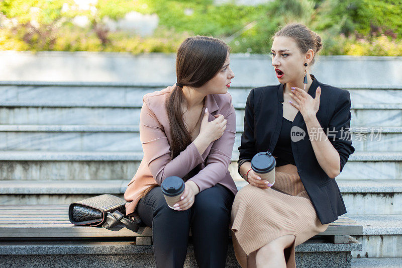震惊了两个商界女性朋友的八卦，而坐在户外的长凳上