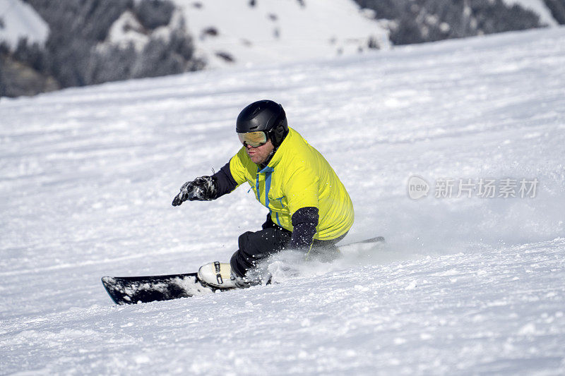 男子在滑雪板上切割滑雪坡