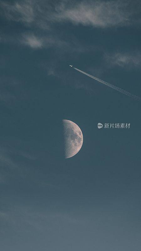 垂直拍摄的飞机在蓝色的天空中飞过月球