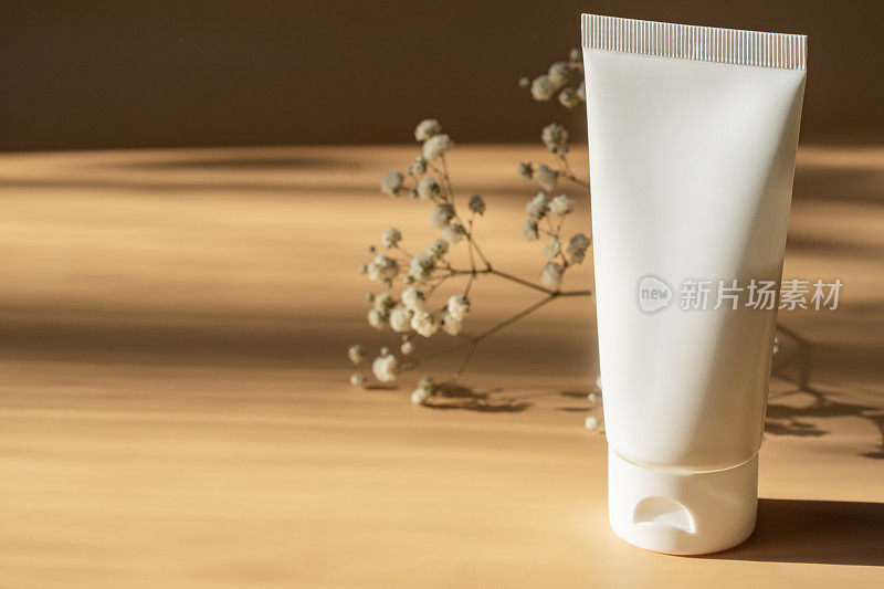 白色挤压瓶塑料管的模型，用于药品或化妆品的品牌-面霜，凝胶，皮肤护理，牙膏。米色背景的化妆瓶容器。严厉的shadowsMinimalism。