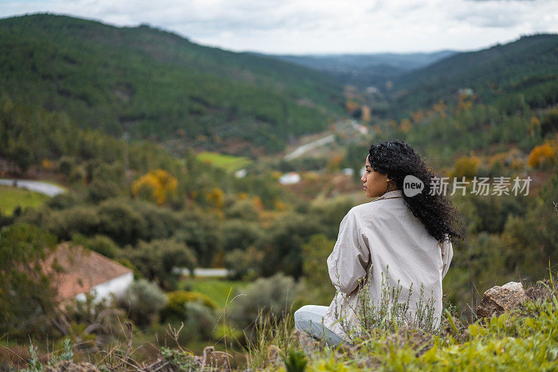 一名女子凝视着山上的景色