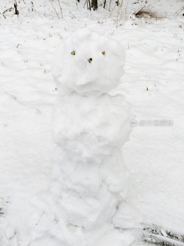 空雪人站在雪地里。