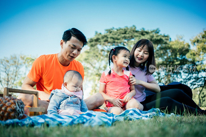 一家人在公园的毯子上享受野餐