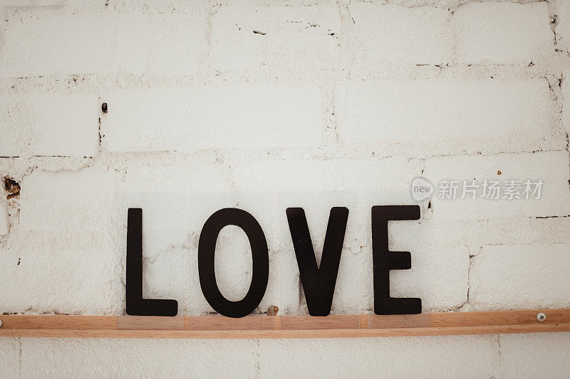白色砖墙上的“爱”标志的特写