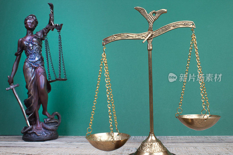 法律概念-在法庭或执法办公室的桌子上打开法律书，天平，忒弥斯雕像。