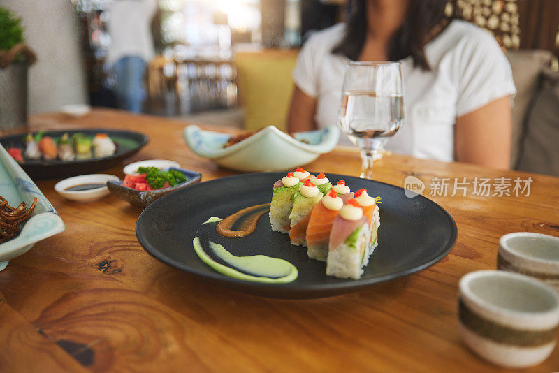 餐桌上，吃着和人们一起在寿司餐厅吃鱼、吃中餐或饿肚子。特写，盘子和一个人与海鲜，午餐或晚餐在一个精致的餐厅亚洲美食或健康
