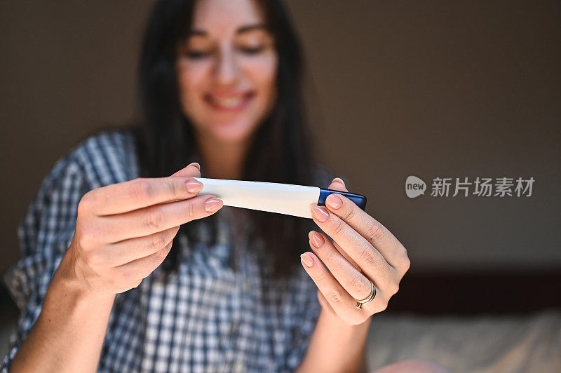 妊娠试验阳性兴奋妇女的近照。