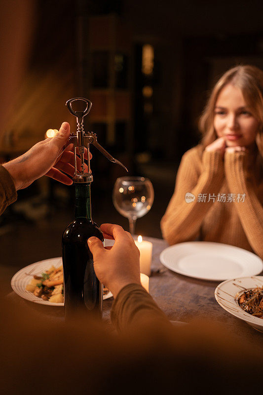 相爱的年轻情侣一边喝着酒，一边吃着浪漫的晚餐，庆祝情人节