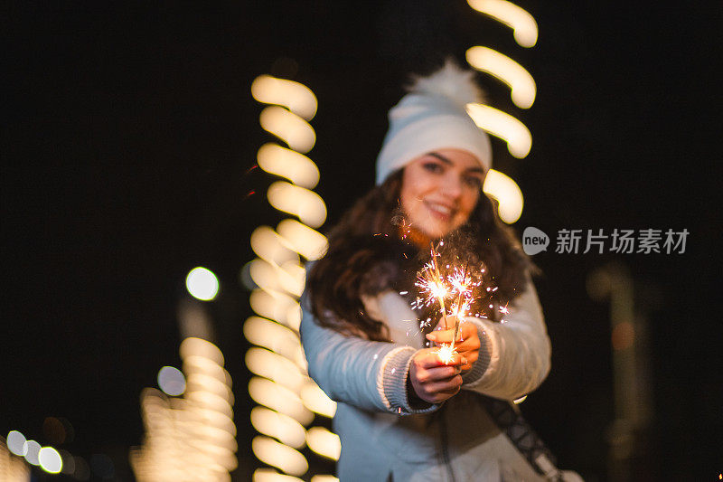 一名年轻女子手持烟花庆祝除夕的特写