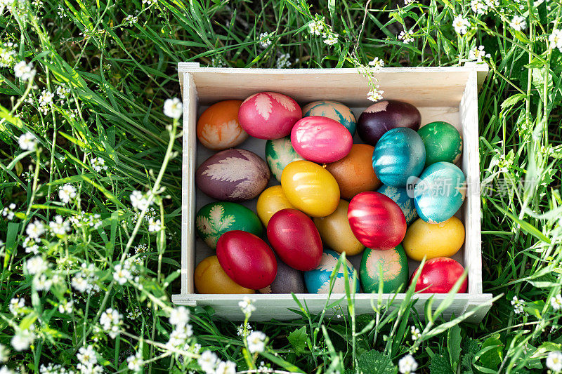 装满五彩彩蛋的木箱躺在草地上