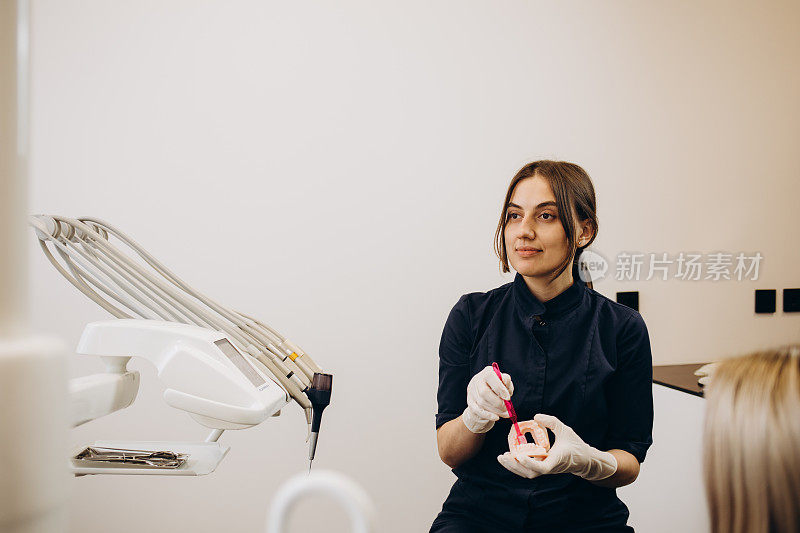 在牙科诊所，一名牙医正在检查病人的牙齿。正在接受牙医检查牙齿的女性。