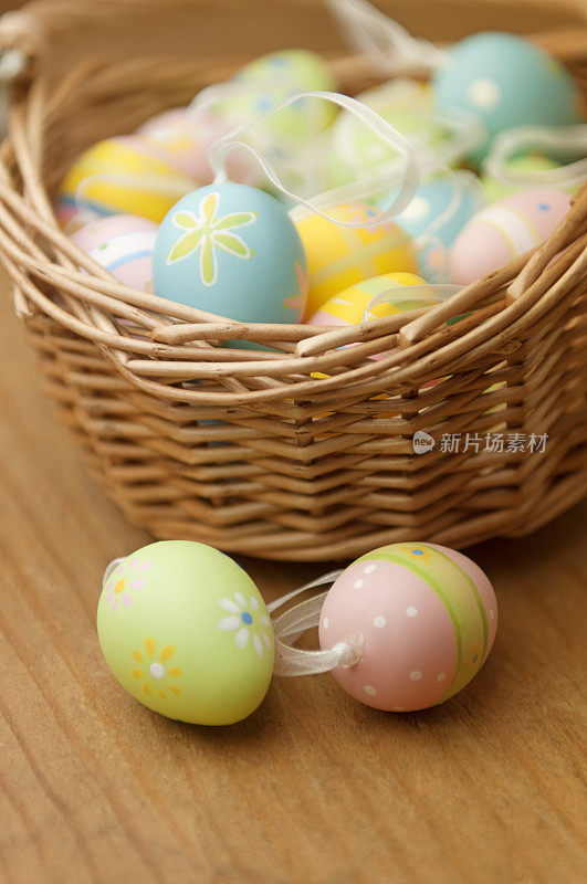 复活节彩蛋放在篮子前面的木桌上