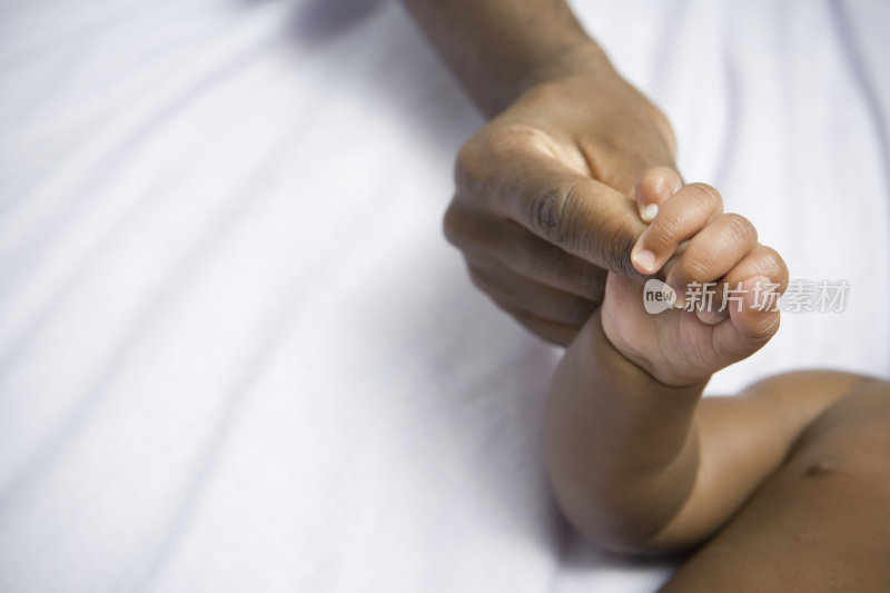 非裔美国人婴儿和母亲手牵着手