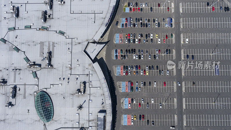 超市屋顶和停车场的许多汽车，从上面看。