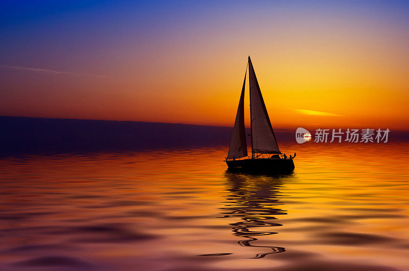 帆船在平静的水面上，在缤纷的日落