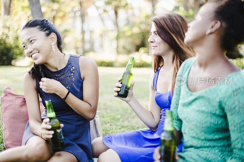 三个年轻女人在公园喝啤酒