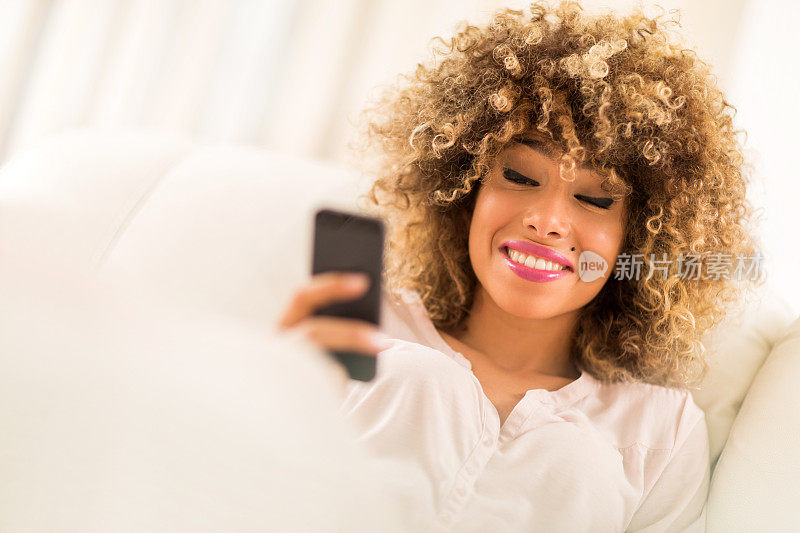 非裔美国女性用智能手机发短信。