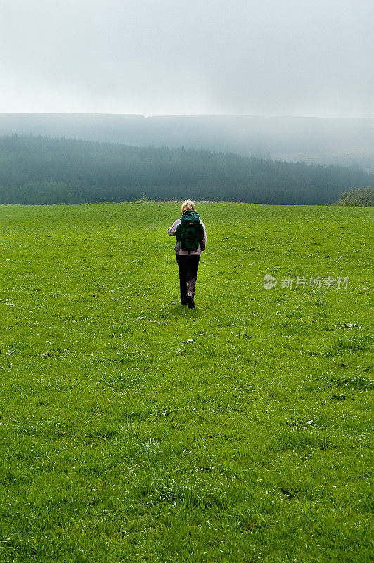 英国雾气弥漫的北约克郡荒原上的女徒步旅行者