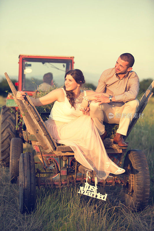 一对新婚夫妇坐在拖拉机上