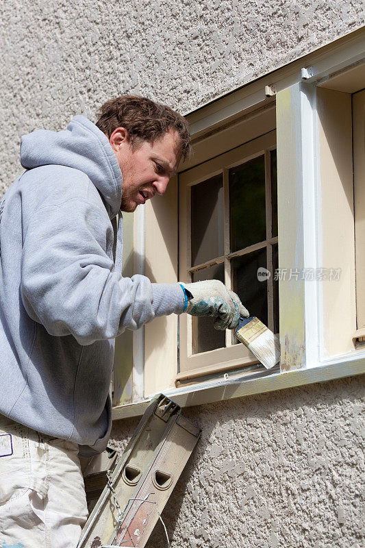 维护房屋油漆工使用油漆刷油漆窗框