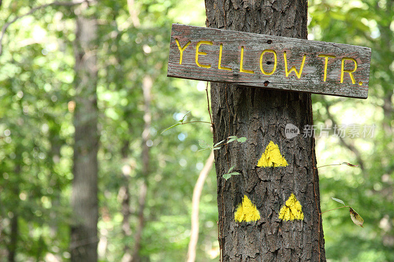 木制黄色小道标志和三角形小道标记