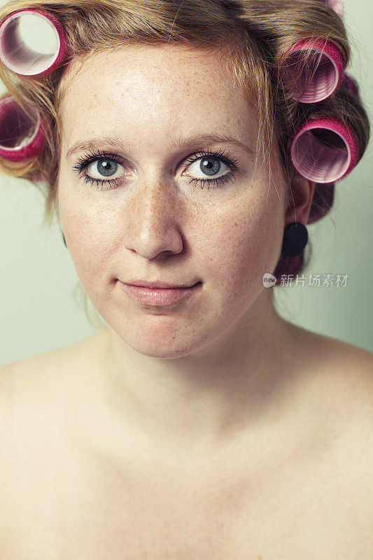 一个带卷发器的年轻女性的肖像